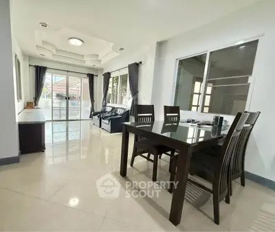 Spacious living and dining area with modern furnishings and large windows for natural light.