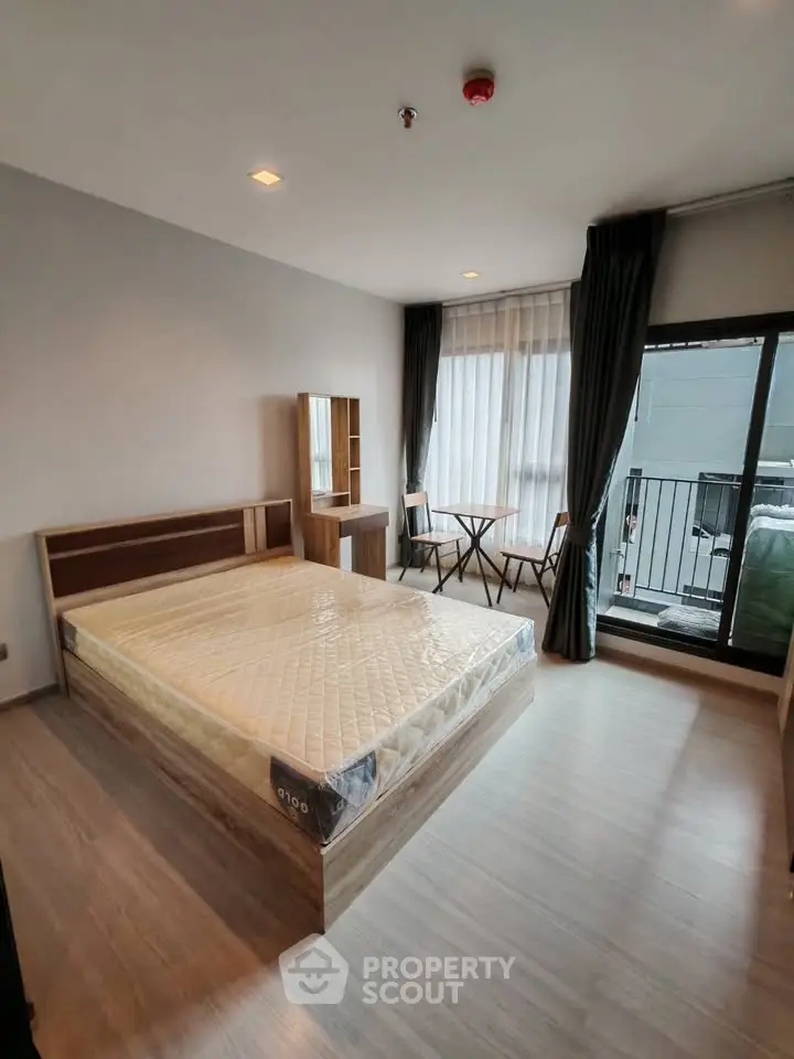 Modern bedroom with balcony access and stylish furniture in a contemporary apartment.