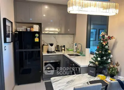Modern kitchen with sleek appliances and festive decor, featuring a marble countertop and stylish cabinetry.
