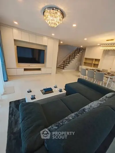 Luxurious modern living room with elegant chandelier and open dining area