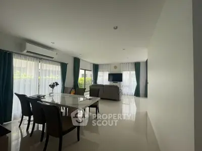 Spacious modern living room with elegant dining area and large windows.