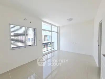 Bright and airy empty room with large windows and balcony access