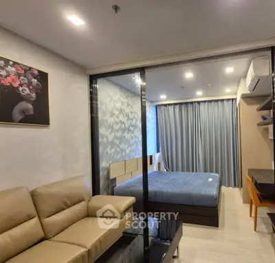 Modern studio apartment with glass partition, cozy sofa, and stylish decor.