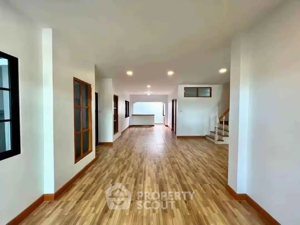 Spacious open-plan living area with wooden flooring and modern design