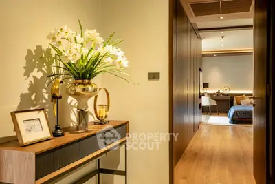 Luxurious hallway leading to a spacious bedroom with elegant decor and warm lighting.