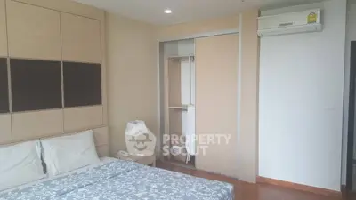 Modern bedroom with built-in wardrobe and air conditioning in a stylish apartment.