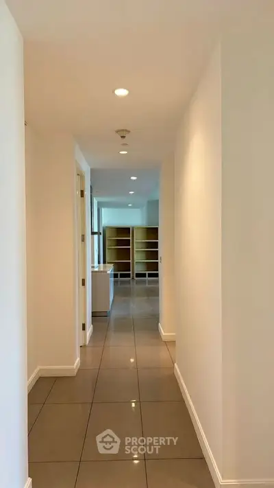 Spacious hallway leading to a bright living area with built-in shelves, perfect for modern living.