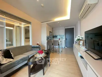Modern living room with open kitchen, stylish decor, and cozy ambiance in a contemporary apartment.