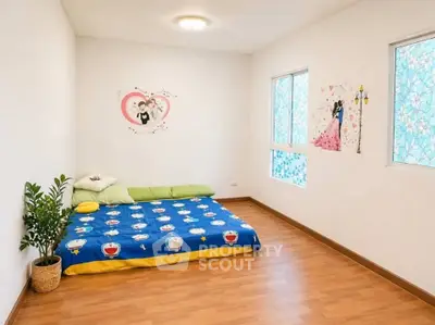 Charming bedroom with cozy decor and natural light, perfect for relaxation.