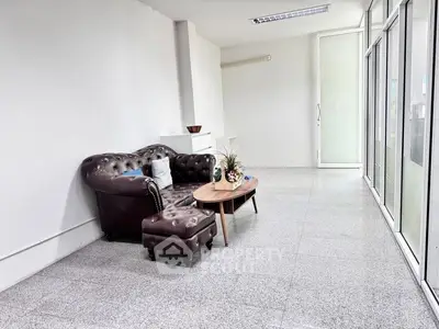 Spacious modern living area with elegant leather sofa and large windows