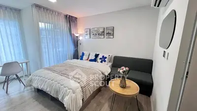 Modern bedroom with cozy bed, stylish decor, and natural light.