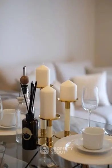 Elegant dining setup with candles and glassware in a cozy living room.