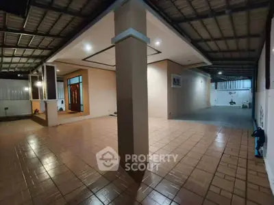Spacious covered patio with tiled flooring and modern lighting, perfect for outdoor gatherings.