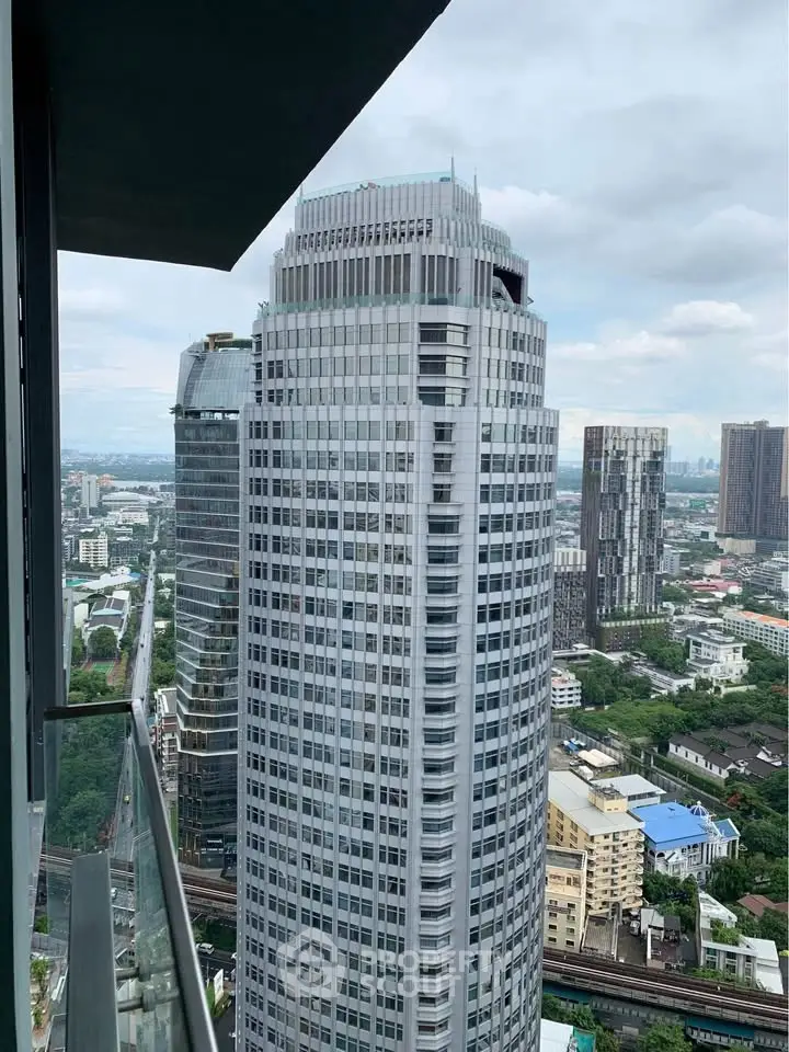 Stunning cityscape view from a high-rise balcony overlooking modern skyscrapers and lush greenery.