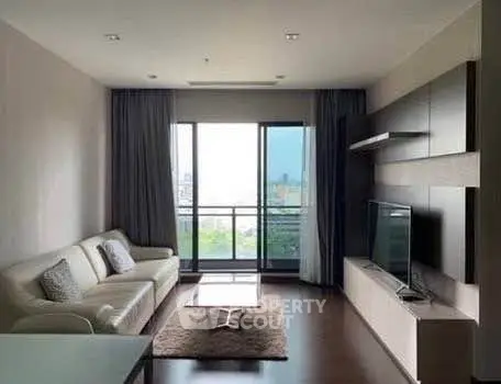 Modern living room with sleek furniture and large window offering city view