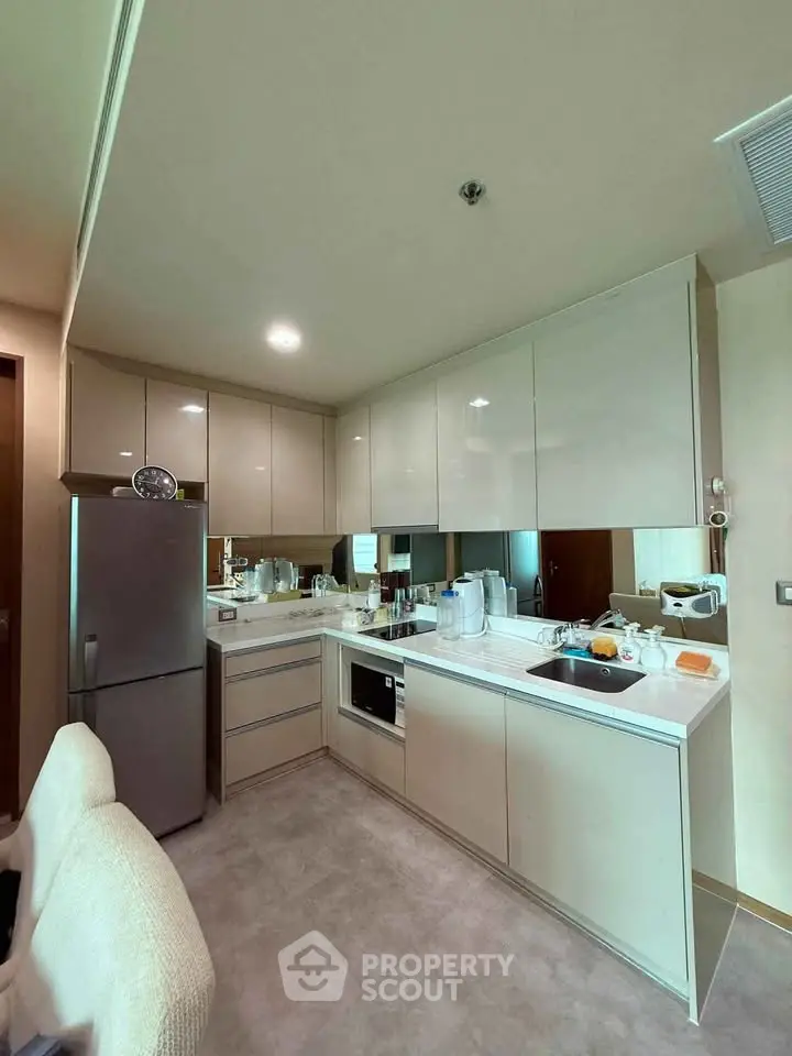 Modern kitchen with sleek cabinets and stainless steel appliances in a cozy apartment.