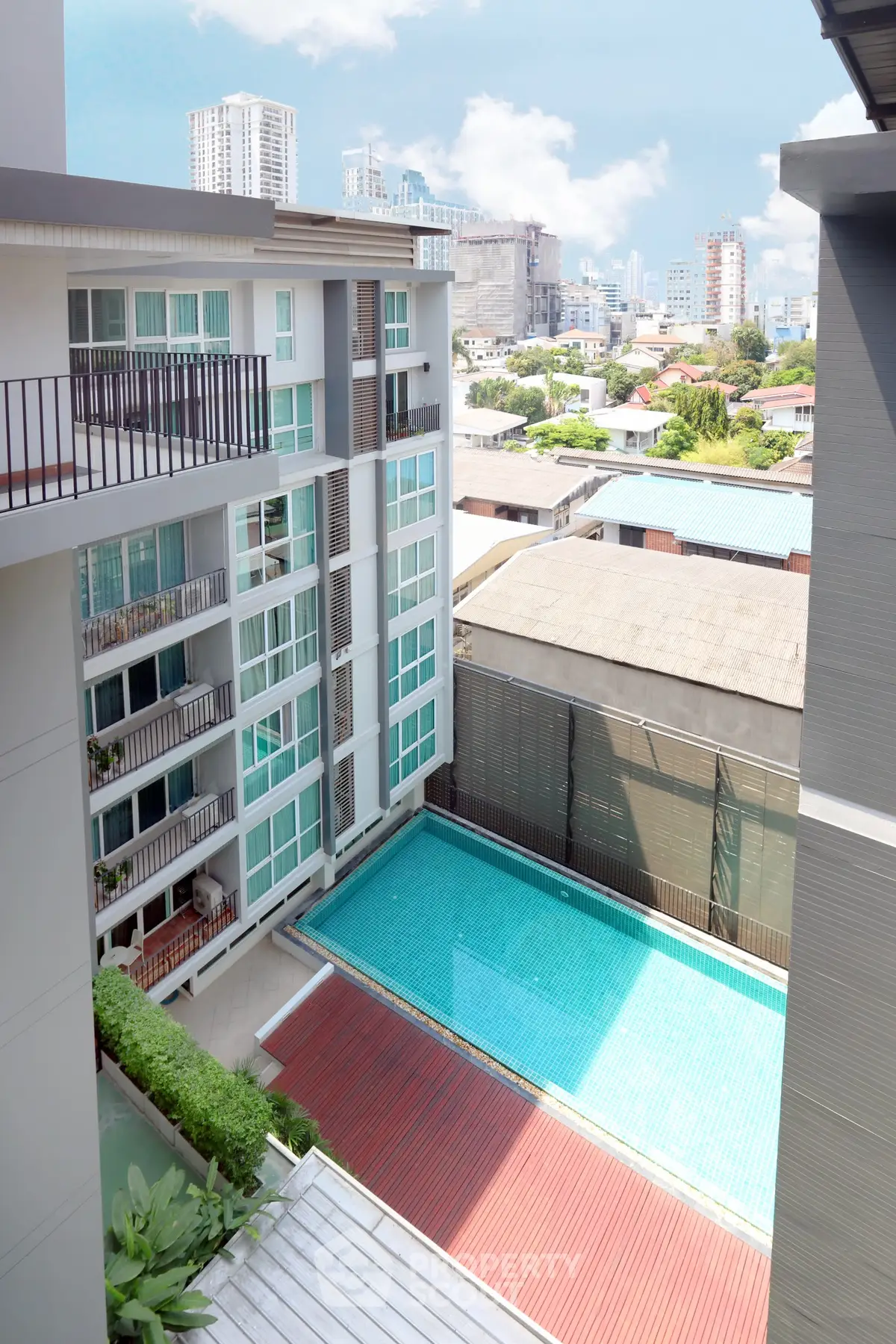 Modern apartment building with pool and city view, ideal for urban living.