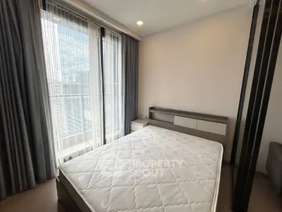 Modern bedroom with large windows and city view, featuring a comfortable bed and sleek furnishings.