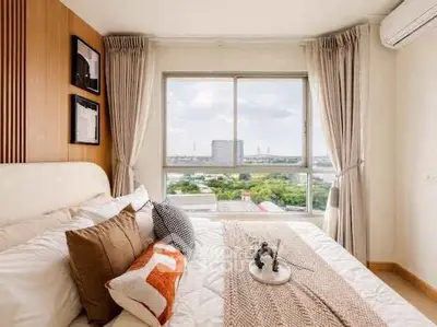 Bright bedroom with large window offering stunning city view, modern decor, and cozy ambiance.