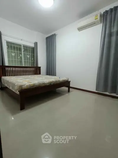 Spacious bedroom with modern decor and air conditioning, ideal for comfort and relaxation.