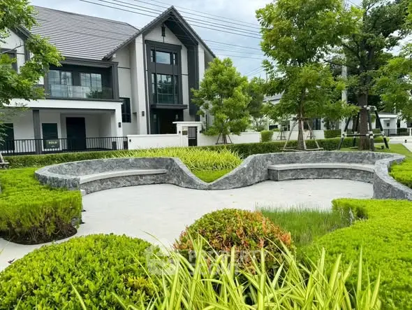 Modern residential building with landscaped garden and seating area