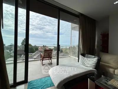 Stunning living room with panoramic ocean view and spacious balcony.