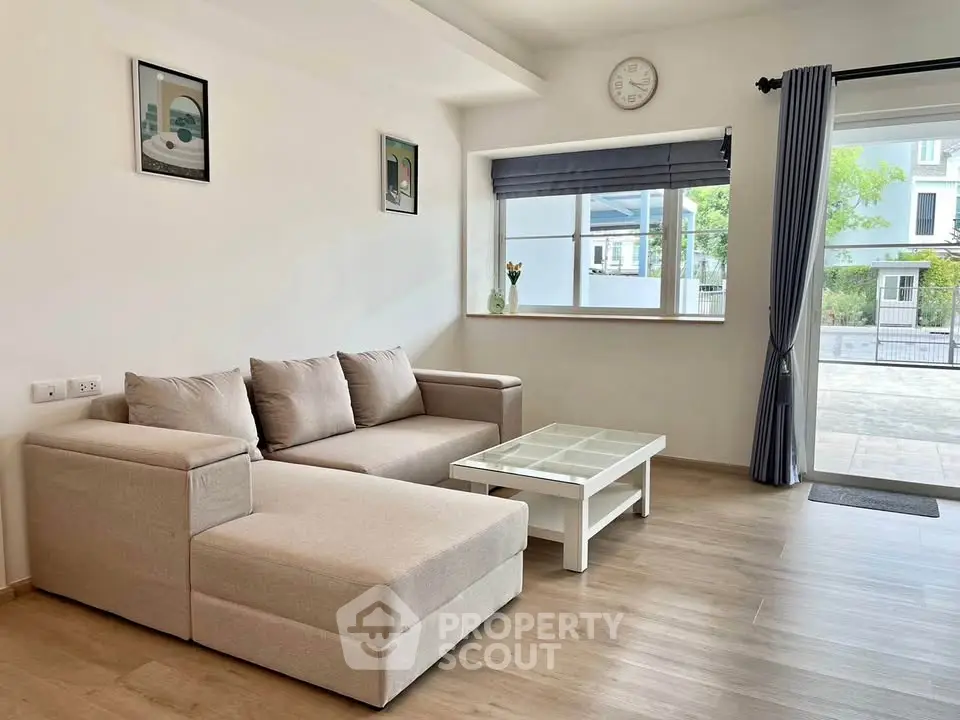 Spacious living room with modern beige sofa and large window view