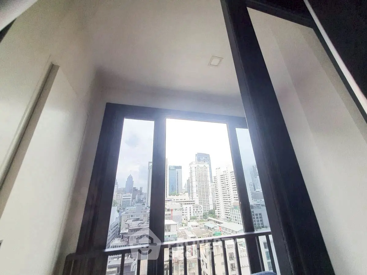 Stunning city view from high-rise balcony with large windows