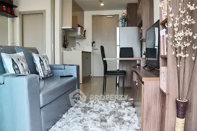 Modern living room with cozy sofa, stylish decor, and compact kitchen in open layout apartment.