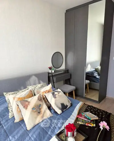 Cozy bedroom with stylish decor, featuring a mirrored wardrobe and elegant vanity set.