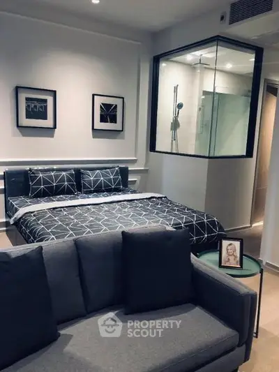 Modern bedroom with stylish decor and glass-enclosed shower area