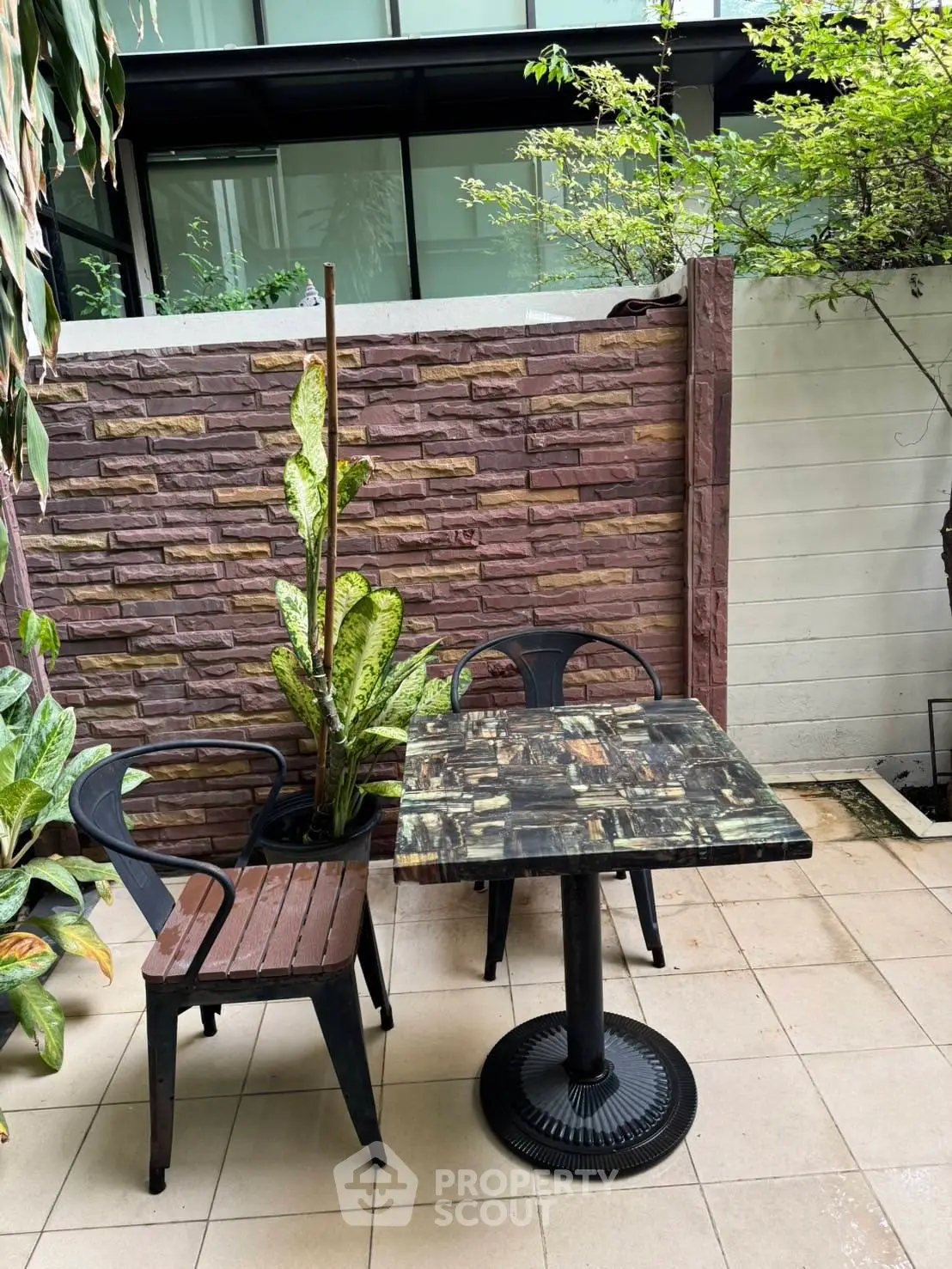 Charming garden patio with modern table and chairs, perfect for outdoor relaxation.