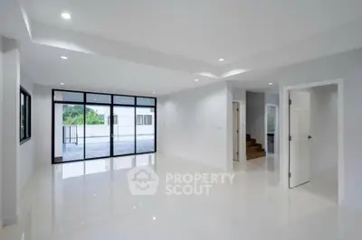 Spacious modern living room with large windows and glossy floors