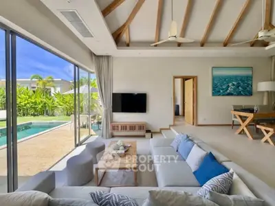 Luxurious living room with pool view, high ceilings, and modern decor in a tropical villa.