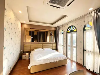 Luxurious bedroom with elegant decor and large windows offering natural light.