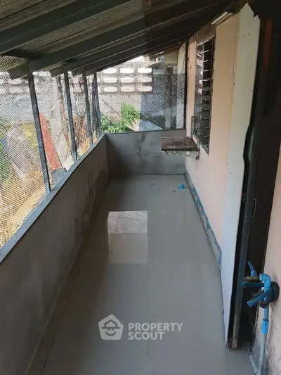 Spacious balcony with tiled flooring and partial roof cover