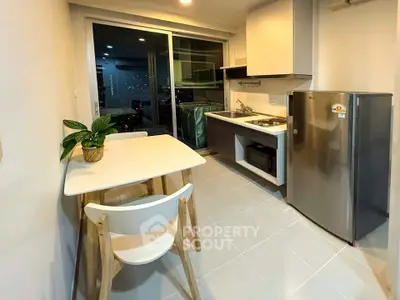 Modern kitchen with sleek appliances and dining area in a stylish apartment.