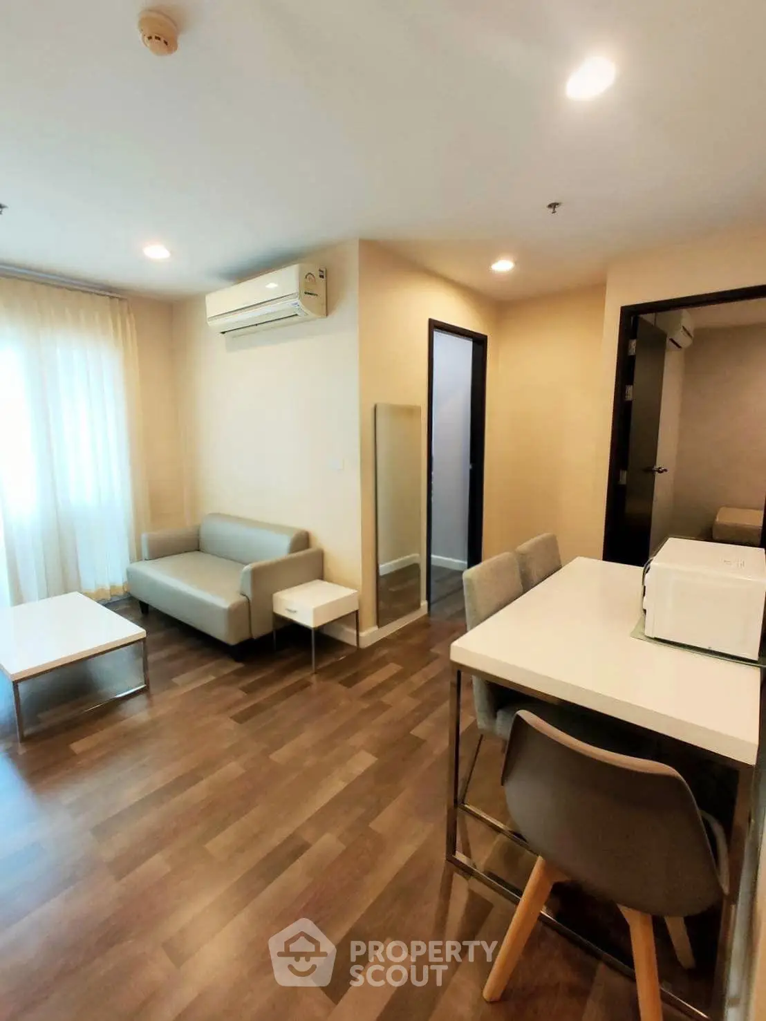 Modern living room with sleek furniture and dining area in a cozy apartment.