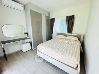 Cozy bedroom with modern decor, featuring a comfortable bed, stylish wardrobe, and elegant vanity desk.