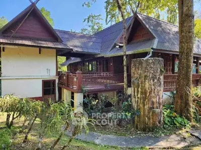 Charming traditional wooden house with lush garden and serene surroundings.