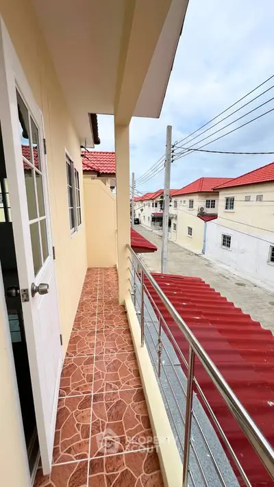 Charming balcony with red roof views in a residential neighborhood, perfect for relaxing outdoors.