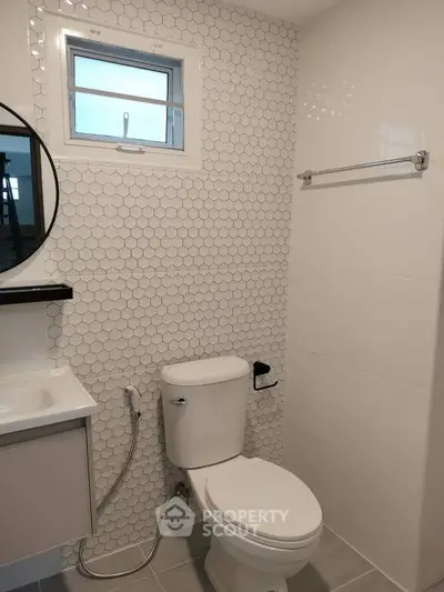 Modern bathroom with hexagonal tile wall and sleek fixtures