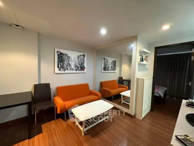 Modern living room with orange sofa and large mirror, stylish decor