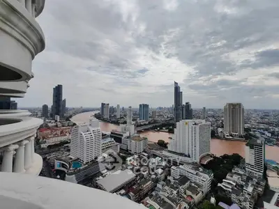 Stunning cityscape view from a high-rise balcony overlooking a river and skyscrapers.