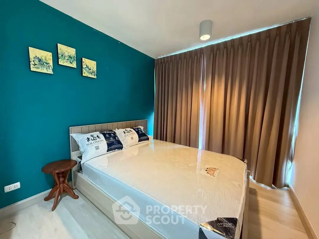 Modern bedroom with teal accent wall and cozy lighting