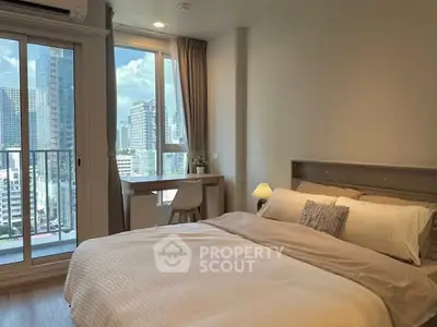 Modern bedroom with city view and cozy decor in high-rise apartment.