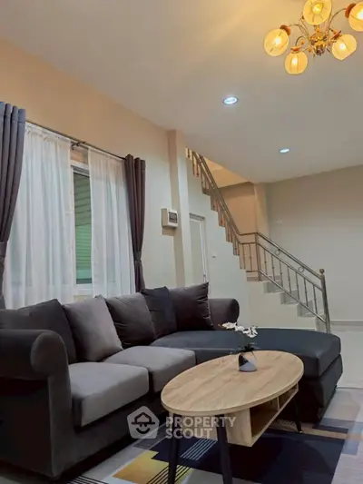 Stylish living room with modern sofa and elegant staircase in a cozy home.