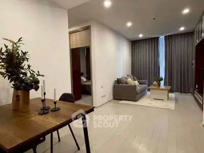 Modern living room with cozy seating and dining area, featuring elegant decor and ambient lighting.