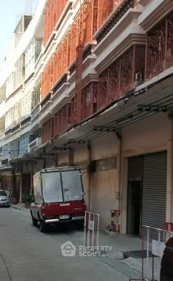 Charming urban street view with vintage architecture and parked vehicle, showcasing vibrant city life.