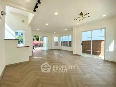 Spacious modern living room with large windows and stylish lighting.